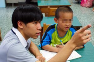 大學生與學童專注互動（圖左：謝元惠同學）